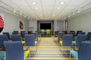 a conference room with chairs and a projection screen at Pestana Brussels Schuman in Brussels