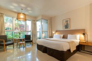 a bedroom with a large bed and a table and chairs at Feel Buenos Aires Apartments in Buenos Aires +47 photos