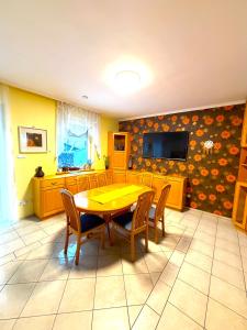 a dining room with a yellow table and chairs at Aurora Premium Home in Győr
