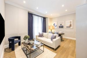 a living room with a couch and a table at Buckingham & Lloyds Knightsbridge in London