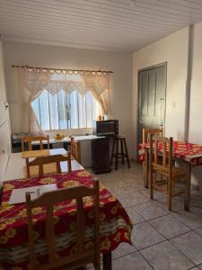 a room with two beds and a table and chairs at Pousada da Salete in Campo Mourão