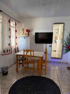 a dining room with a table and chairs and a television at Pousada da Salete in Campo Mourão