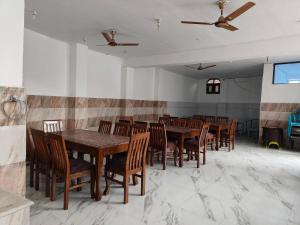 a dining room with wooden tables and chairs at Hotel Sada Bahar in Srinagar