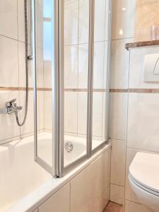 a bathroom with a shower and a toilet at Alpenhof Garnihotel & Ferienwohnungen in Garmisch-Partenkirchen +34 photos