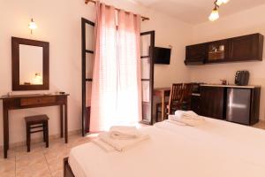 a room with two beds and a table and a mirror at Casa di Dandolo in Parga