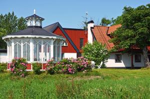 a gazebo in front of a house with flowers at Torsborgs Gård in Simrishamn +93 photos