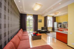 a living room with a red couch and a kitchen at Abylai Khan 113 Central in Almaty