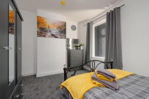 a bedroom with a bed with a yellow blanket at Family-Friendly 2-Bed Home with Games & Fireplace in Colne