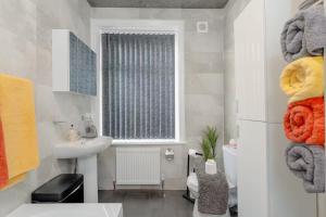 a bathroom with a sink and a window with towels at Family-Friendly 2-Bed Home with Games & Fireplace in Colne