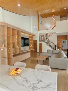 a living room with a table and a couch at Chaisona at Khanom Storey in Ban Phaeng