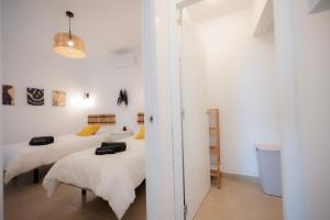 two beds in a room with white walls at Carlota Cake in Fuencaliente de la Palma
