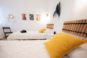 a bedroom with two beds with yellow pillows at Carlota Cake in Fuencaliente de la Palma