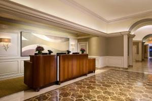 a lobby with a reception desk in a building at Houston Grand Hotel - River Oaks in Houston