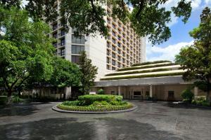 a building with a garden in the middle of a courtyard at Houston Grand Hotel - River Oaks in Houston