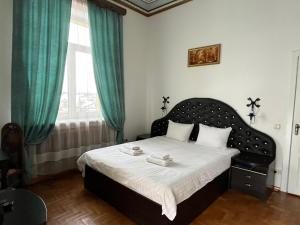 a bedroom with a bed with green curtains and a window at Приватна садиба Фортеця Малехів in Lviv