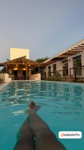 a person swimming in a swimming pool in a building at BaleiaLofts Kite Village in Itapipoca