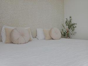 a white bed with two pillows on top of it at Villa Abril 56 in Oreña