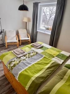 a bed with a green comforter in a bedroom at Dolpo 55 - Pouze pro dospělé in Benešov