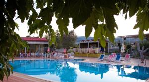 a pool with chairs and tables and a building at Aigai Hotel in Edessa