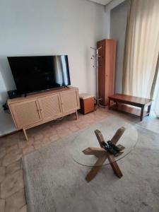 a living room with a tv and a glass table at Stylish Suite in Larisa +3 photos