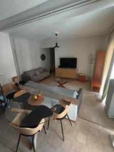 a living room with a couch and a table and chairs at Stylish Suite in Larisa