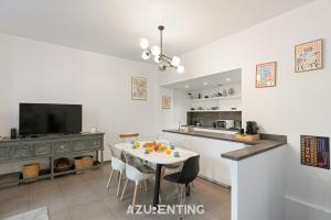 a kitchen with a table with chairs and a tv at Azurenting - Maison Césario - 3 chambres in Cannes