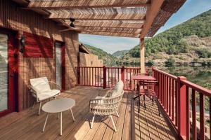 a deck with chairs and tables and a view of a river at Pincelo Nature in Pincelo