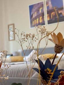 a vase with flowers in a room with a bed at Quattro Venti city suites in Rome