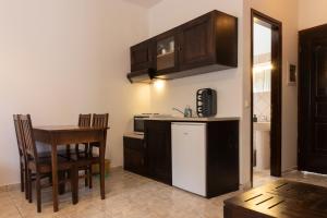 a kitchen with a table and a refrigerator and cabinets at Casa di Dandolo in Parga +31 photos