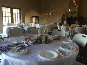 a dining room with a table with plates and silverware at The Cradle Berry Farm in Muldersdrift