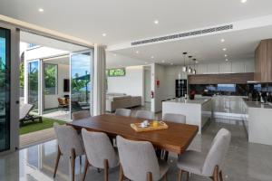 a kitchen and dining room with a wooden table and chairs at OurMadeira - BeachFront in Madalena do Mar