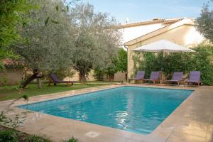 a swimming pool with chairs and an umbrella at Bamboo Garden Oasis with Pool in Pula