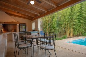 a dining room with a table and chairs next to a pool at Bamboo Garden Oasis with Pool in Pula