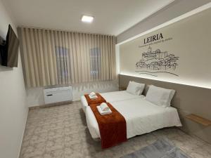 a hotel room with a bed and a sign on the wall at Pombal City House in Pombal +46 photos