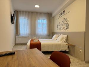a hotel room with a bed and a table at Pombal City House in Pombal