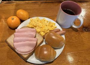 a plate of breakfast foods with a cup of coffee at Santana Lodge Hakuba in Hakuba