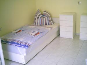 ein kleines Schlafzimmer mit einem Bett und einer Kommode in der Unterkunft Ela`s Ferienoase Haus Ketsching in Görcsönydoboka