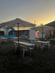 a group of tables and chairs with umbrellas at Shukran Habibi Resort in Santa Rita