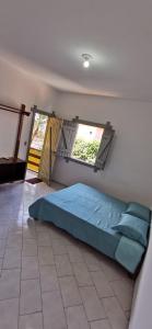 a bedroom with a bed in a room with a window at Verde & Sal 14 in Ilhéus