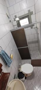 a small bathroom with a toilet and a window at Verde & Sal 14 in Ilhéus