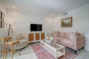 a living room with a couch and a tv at Le Malo Vacation Rental in Naples