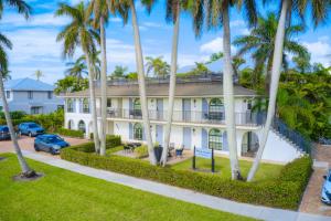 a house with palm trees in front of it at Le Malo Vacation Rental in Naples
