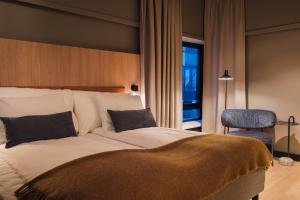 a bedroom with a large bed and a chair at Quality Hotel Grand Steinkjer in Steinkjer