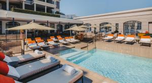 ein Swimmingpool mit Liegestühlen und Sonnenschirmen in der Unterkunft Cape Grace, A Fairmont Managed Hotel in Kapstadt