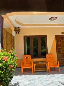 two orange chairs and a table on a patio at Phu Lanta Life Resort in Ko Lanta