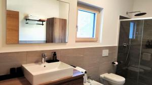 a bathroom with a sink and a toilet and a mirror at Rauchhof in Auer +13 photos