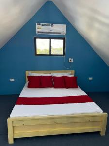 a bed with red pillows in a blue room at Shukran Habibi Resort in Santa Rita +34 photos
