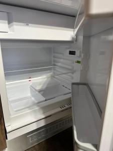 an empty refrigerator with its door open and its empty shelves at La Cabine Noire - Foppolo in Foppolo