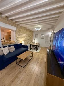 a living room with a blue couch and a tv at DUPLEX SUBLIME ET LUMINEUX au CENTRE VILLE 10 minutes de Paris Parking privée souterrain in Rueil-Malmaison