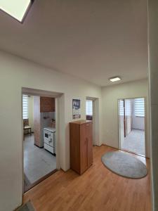 an empty living room with a refrigerator and a kitchen at Apartman Daki in Vareš +1 photo